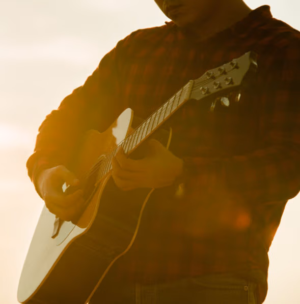 Asian man acoustic guitar silhouette with sunset background